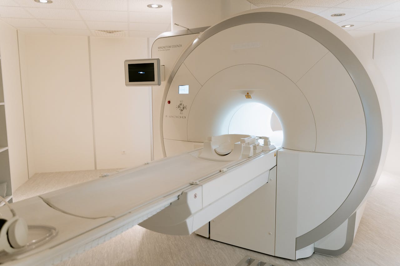 Services A state-of-the-art MRI scanner in a well-lit hospital room, ready for patient use.